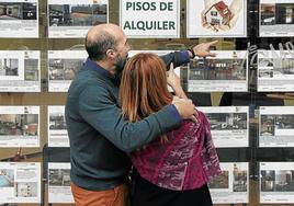 Una pareja observa ofertas de alquiler en una inmobiliaria en una imagen de archivo.
