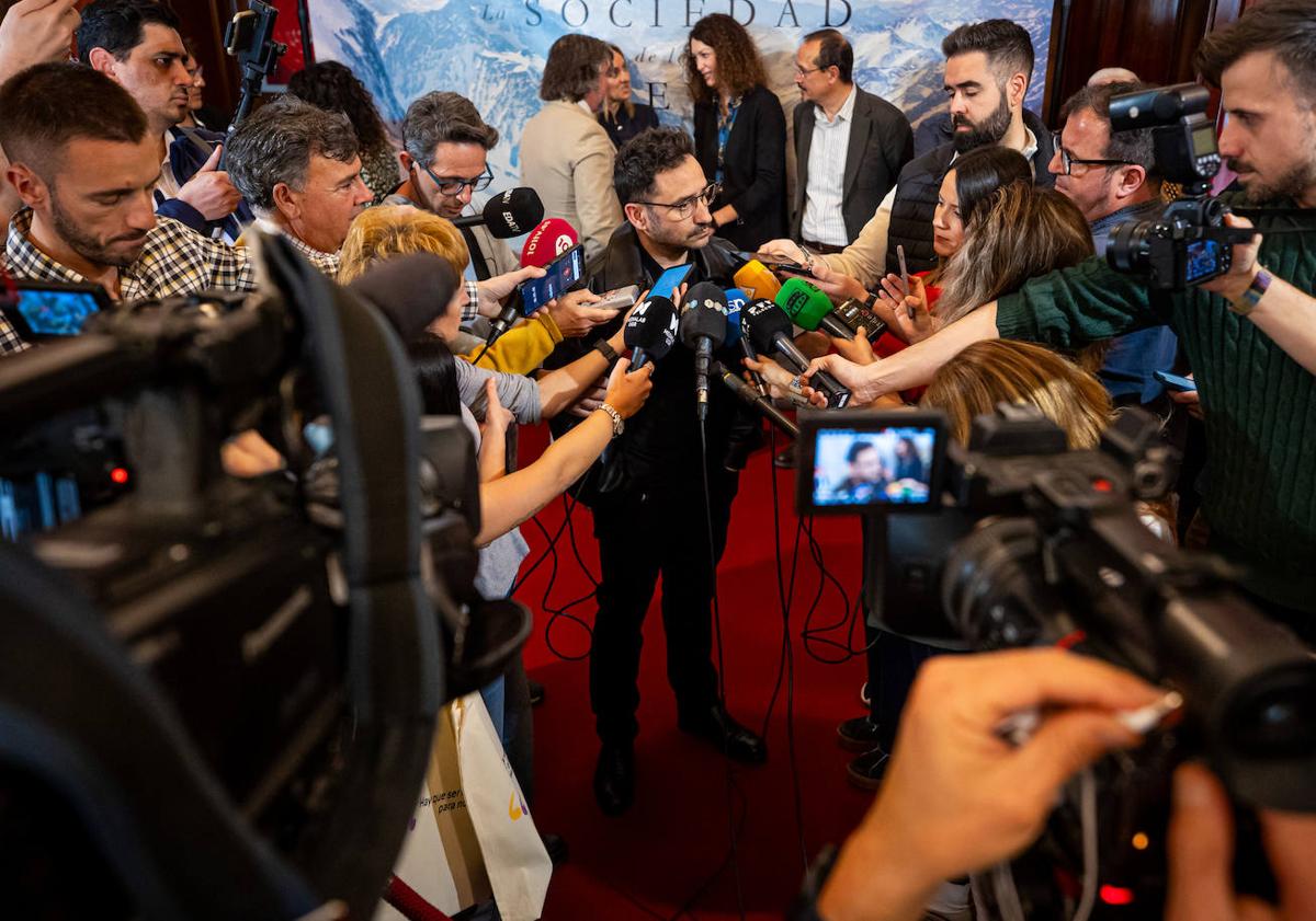 Imagen principal - Bayona atiende a los medios y señala el suelo de Sierra Nevada; la productora Sandra Hermida. 