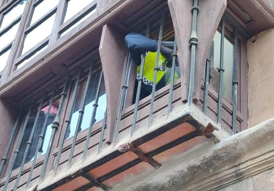Un Policía Local de Granada retira los cristales de la ventana.