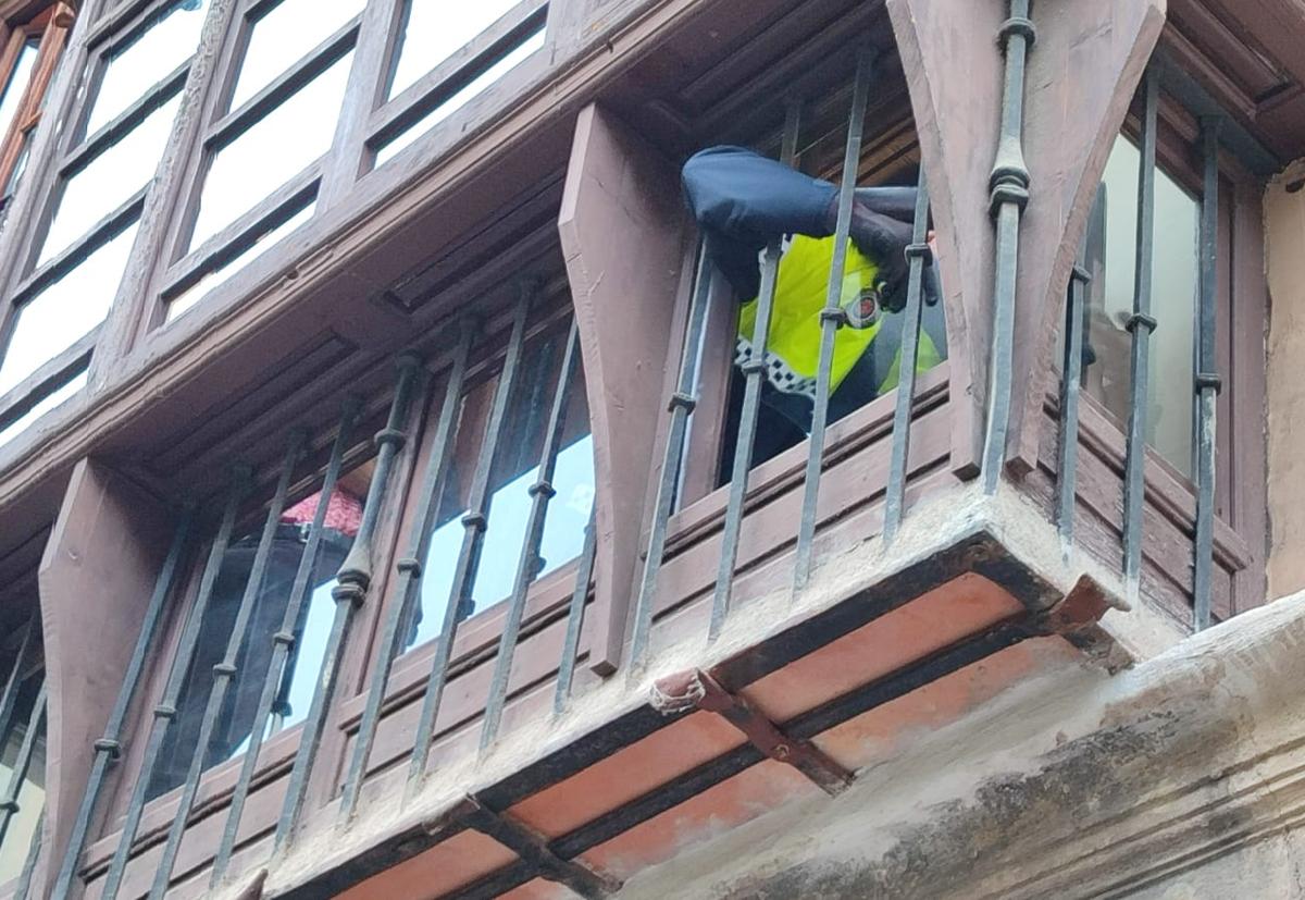 Un Policía Local de Granada retira los cristales de la ventana.