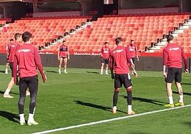 Myrto Uzuni, al fondo a la izquierda, y Lucas Boyé, de espaldas a la derecha, durante los rondos de calentamiento en el entrenamiento del Granada este miércoles en Los Cármenes.