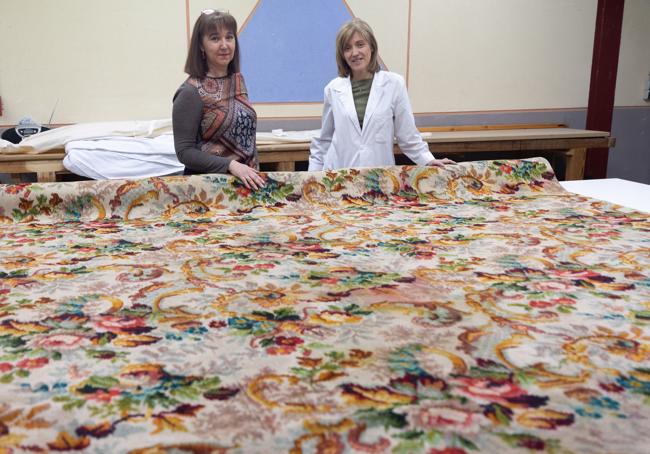 Susana Rodríguez y Teresa del Pino, jefa de estudios y profesora del Centro Albayzín, con la alfombra.