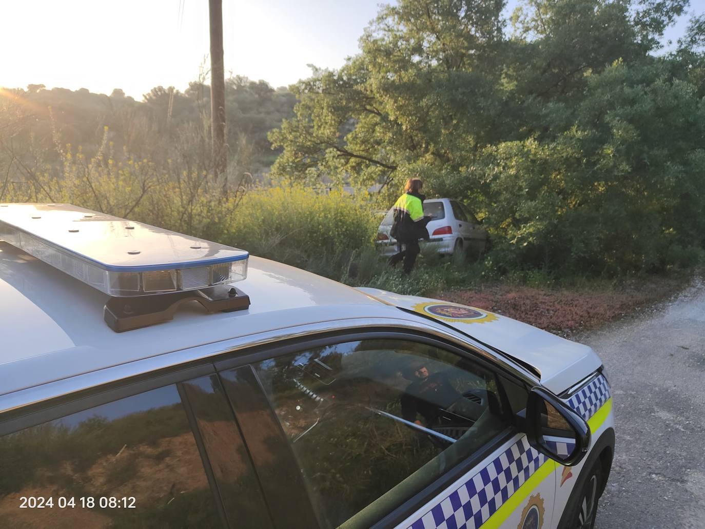 La Policía Local de Íllora, junto al coche accidentado.