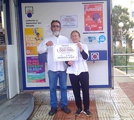 Los dueños del kiosco posan con el diploma.