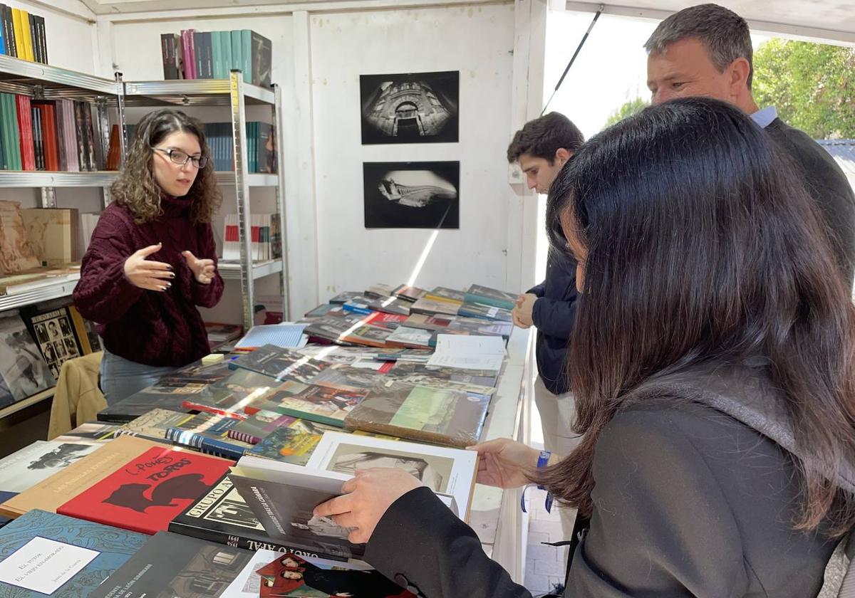 Una mujer se interesa por un libro en una de las casetas.