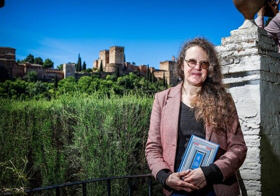 Doucet, en el Carmen de la Victoria, con vistas a la Alhambra y un ejemplar de su último cómic, 'El Río'.