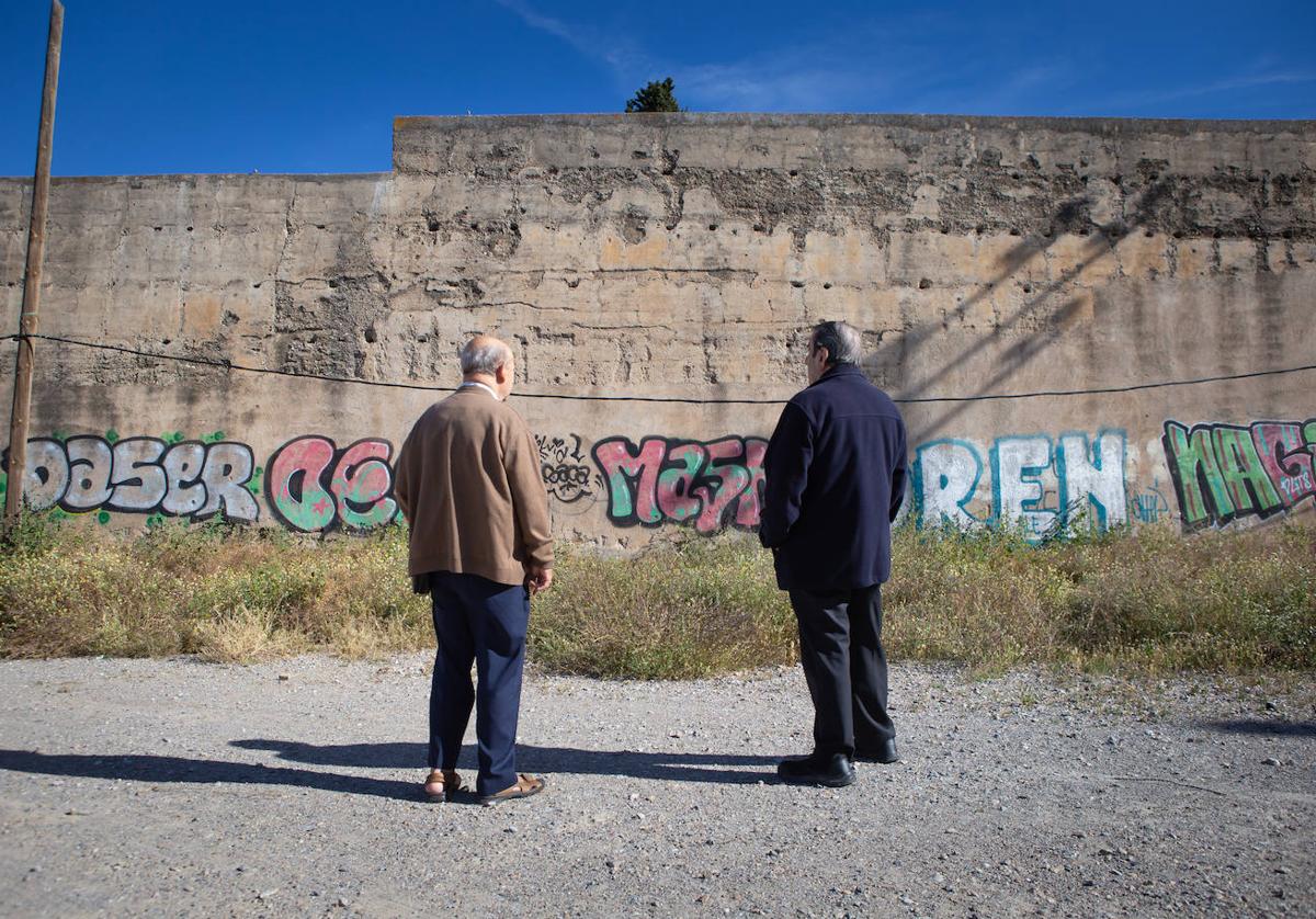 Dos lugareños observan las pintadas en la Muralla de la Alberzana.