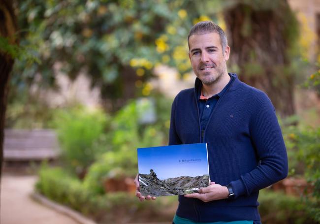 Cristóbal Adrián García muestra la portada del libro sobre los refugios de Sierra Nevada.