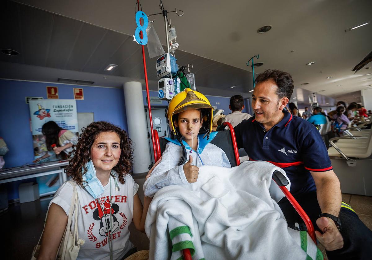 Imagen principal - Víctor hace la señal de triunfo con su casco de bombero. Los niños y niñas ingresados se lo pasaron estupendamente.