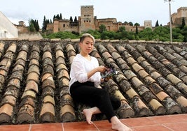 Wakana Sakamoto, en la terraza de su casa, con un ejemplar de 'Hero Mask' y vistas a la Alhambra.