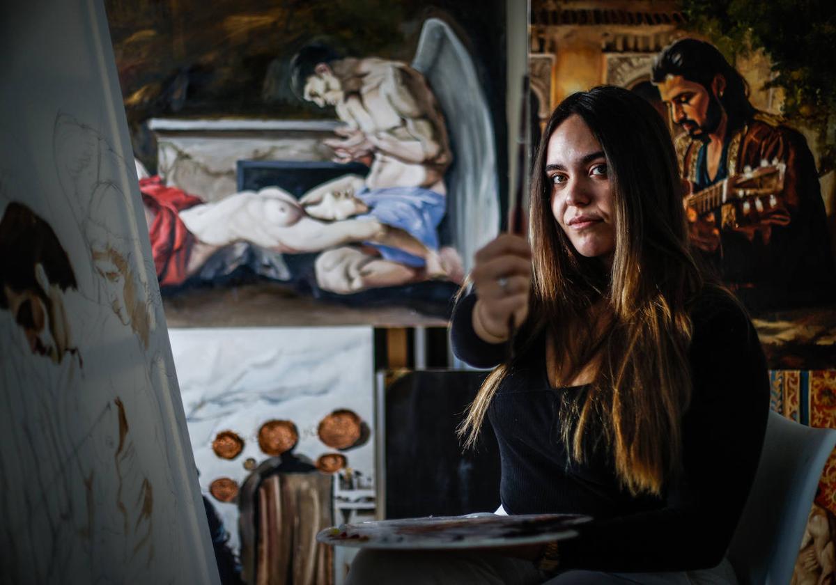 Elena Ruiz posa en su estudio, en Pinos Puente, rodeada por algunas de sus pinturas.