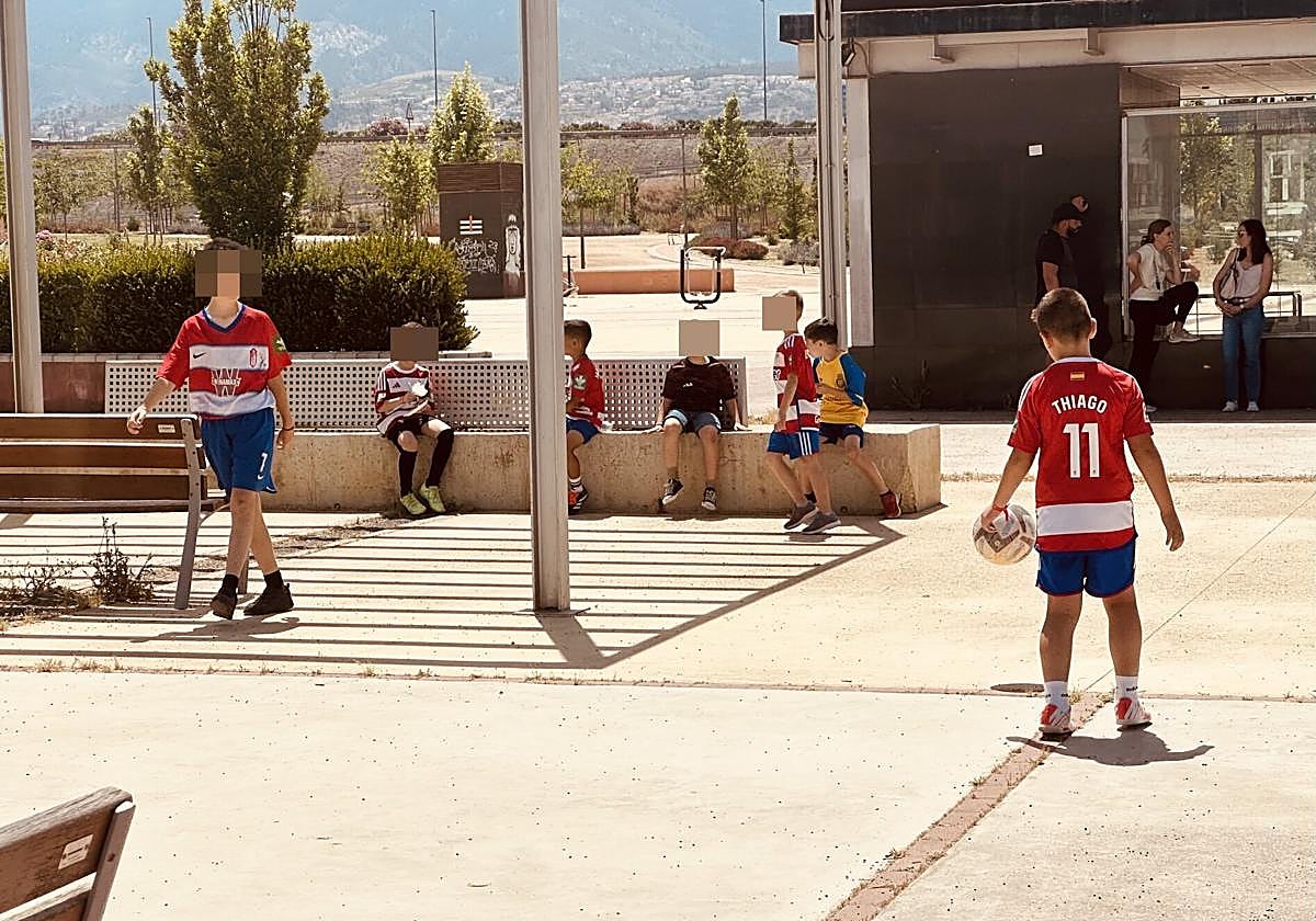 Niños con la camiseta del Granada juegan en una placeta cerca de Los Cármenes.