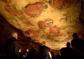 Investigadores contemplan las pinturas rupestres en el interior de la Cueva de Altamira.