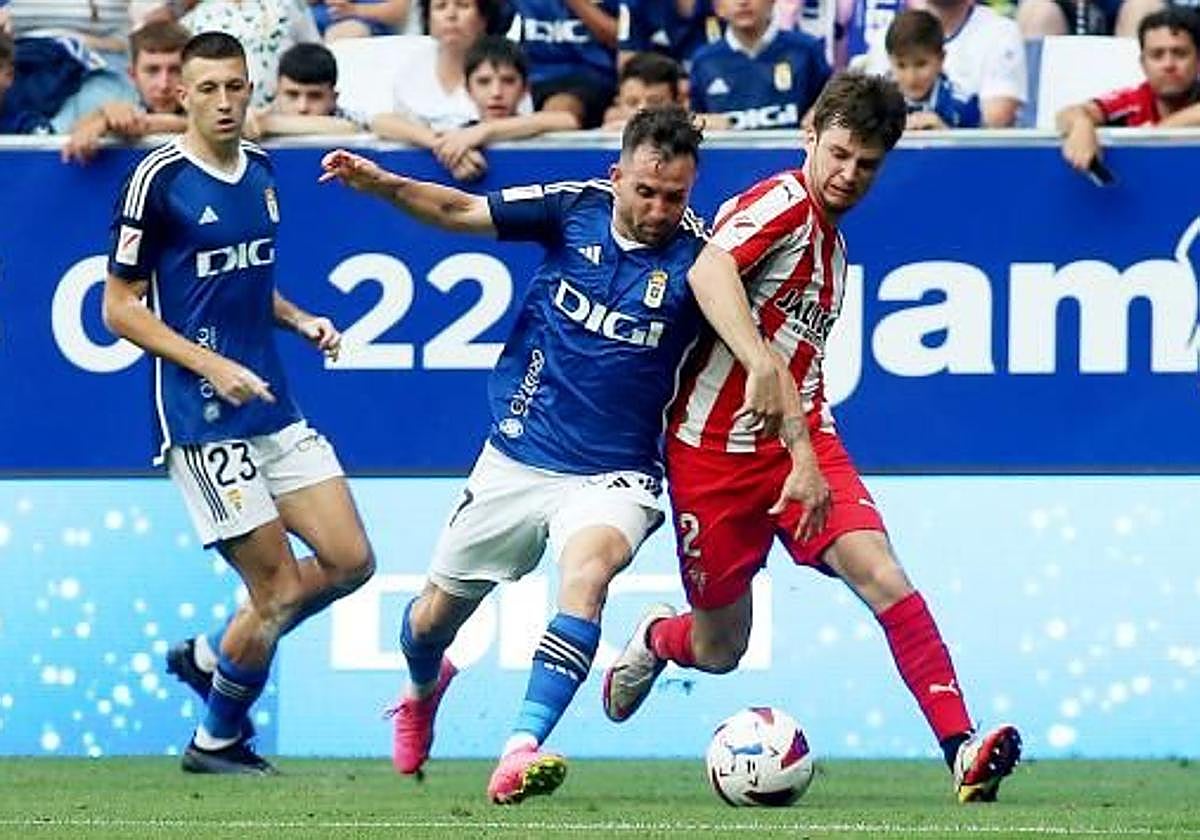 Sebas Moyano disputa un balón con Guille Rosas, del Sporting, en el Carlos Tartiere.