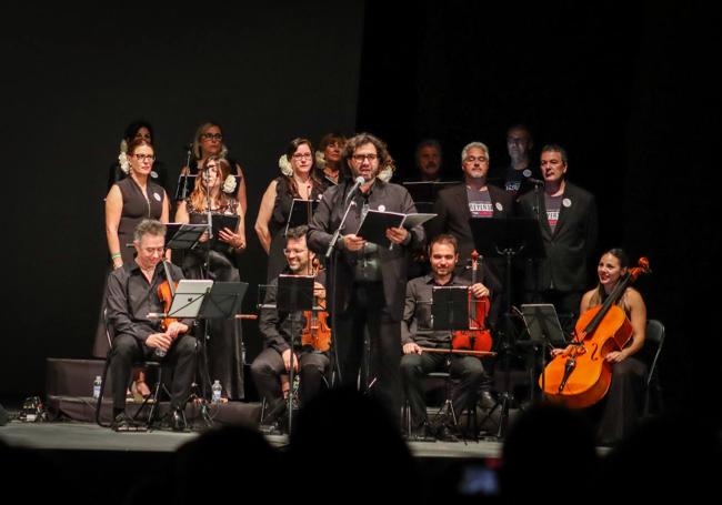 El director del coro se dirige al público.