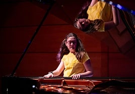 Olga, reflejada en la tapa del instrumento con el aprende en el Auditorio de la Rural.