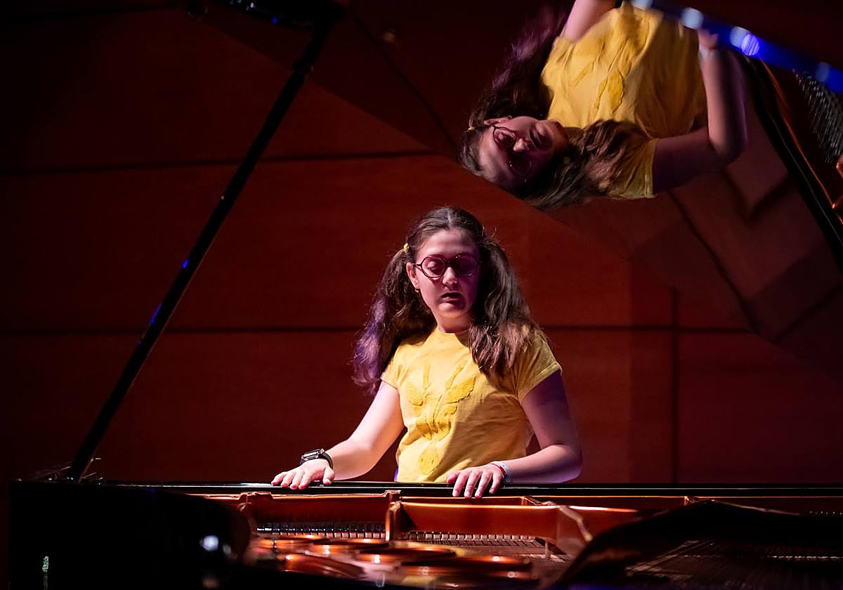 Olga, reflejada en la tapa del instrumento con el aprende en el Auditorio de la Rural.