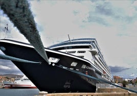 Un crucero, amarrado al puerto de Almería, con la ciudad y la Alcazaba al fondo.