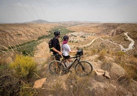 Una pareja de turistas franceses observa el Geoparque desde un mirador de Gorafe.