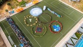 Los niños formaron los aros olímpicos en el patio del colegio.