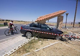 Un ciclista observa el coche siniestrado en Ogíjares.