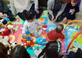 Las madres, junto con sus hijos menores, juegan en la casa de acogida.