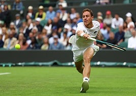 Roberto Carballés pelea por llegar a una bola sobre la hierba de Wimbledon.