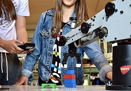 Dos estudiantes dan órdenes a un autómata en el Desafío del Club de Robótica.
