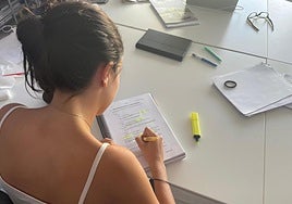 Una estudiante subraya unos apuntes.