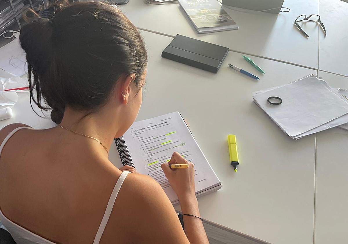 Una estudiante subraya unos apuntes.