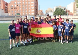 Jóvenes del Campus de Verano EDA posan con la bandera de España en el Estadio de la Juventud 'Emilio Campra'.