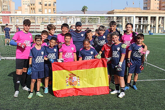 Un equipo de niños disfrutan del campus con el entrenador de porteros, Rafa Pérez