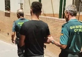 Uno de los detenidos es conducido por la Guardia Civil.