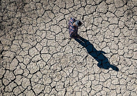 Una persona comprueba el estado de sequía en un pantano, de archivo.