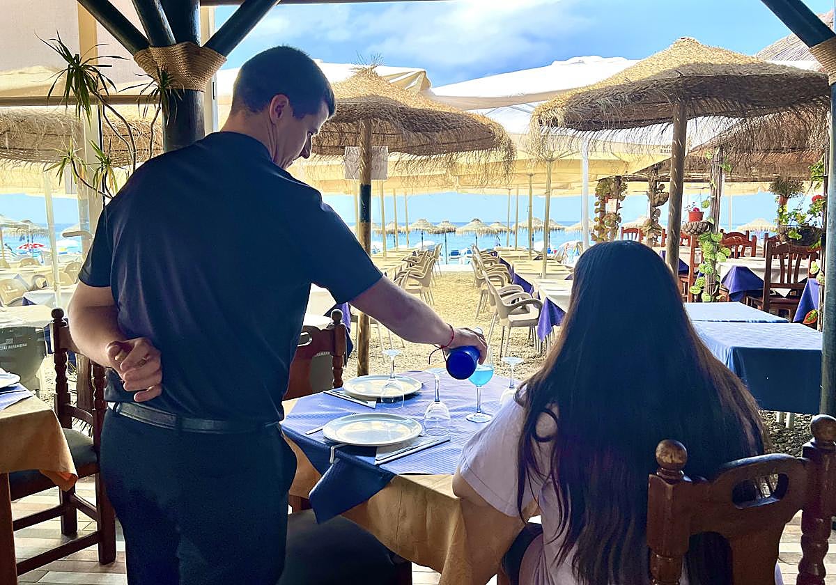 Camarero del Chiringuito Casa Emilio sirviendo una copa de 'vino azul'.