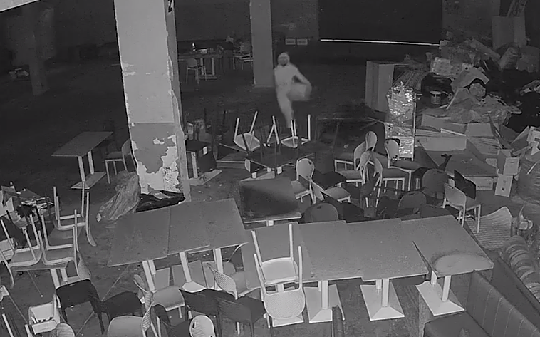 El incendiario, grabado mientras derramaba líquido inflamable en el local.