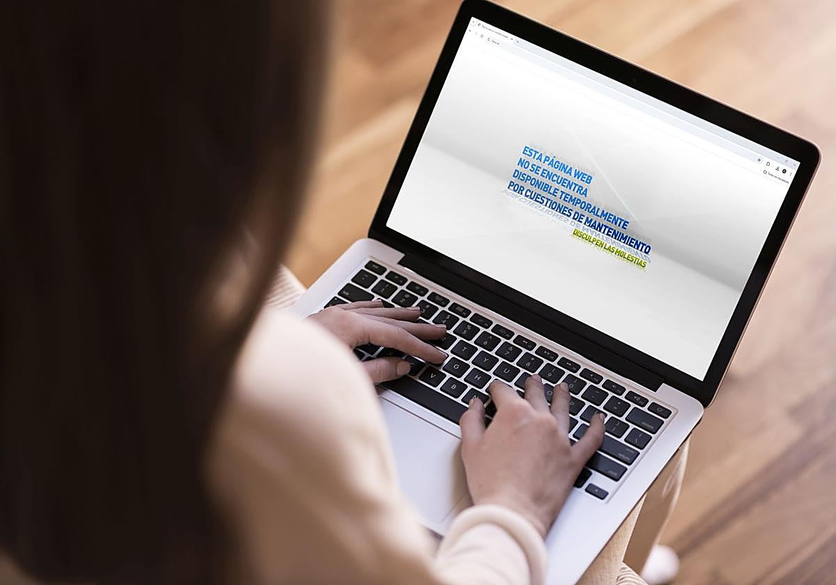 Una mujer observa una web defectuosa en su ordenador portátil.