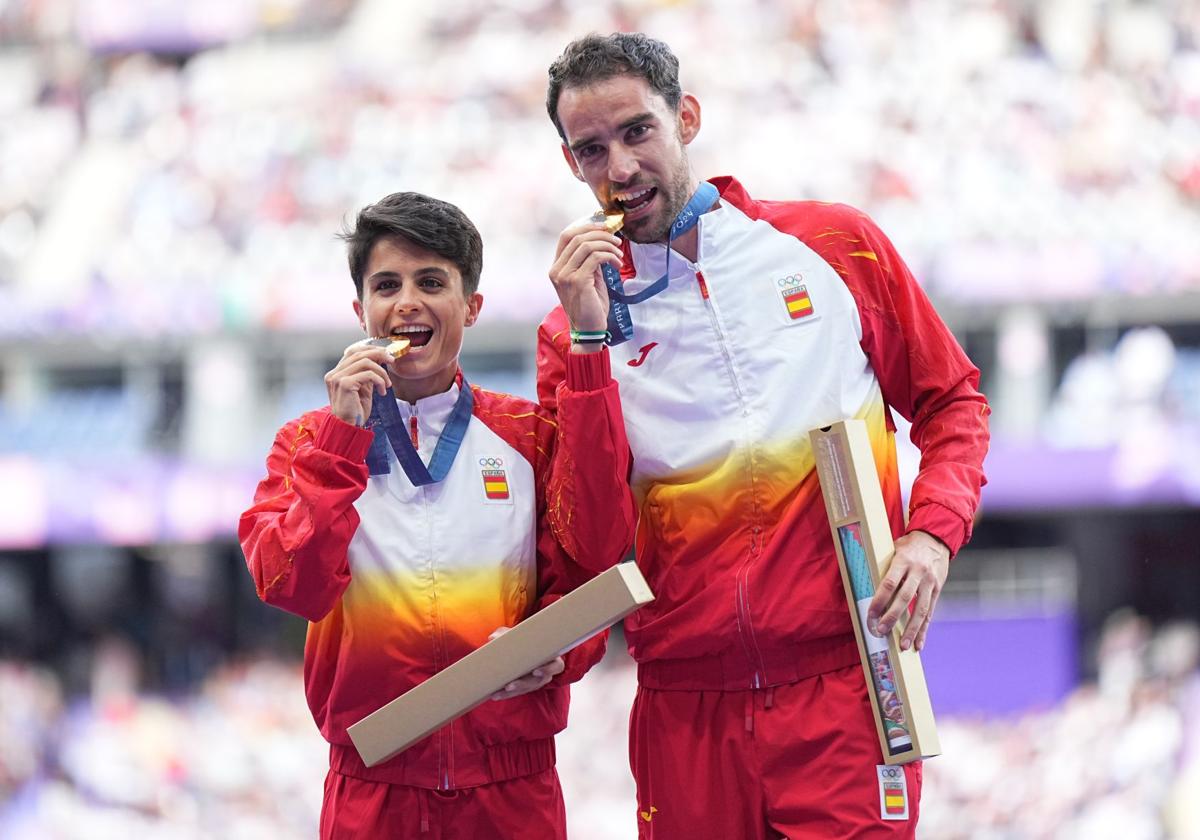 María Pérez y Álvaro Martín muerden sus medallas de oro en la ceremonia de premiación en París.