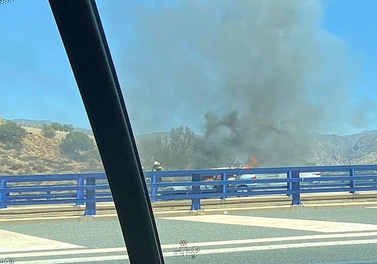 Un coche ardiendo en el viaducto sobre el arroyo de Dúrcal.