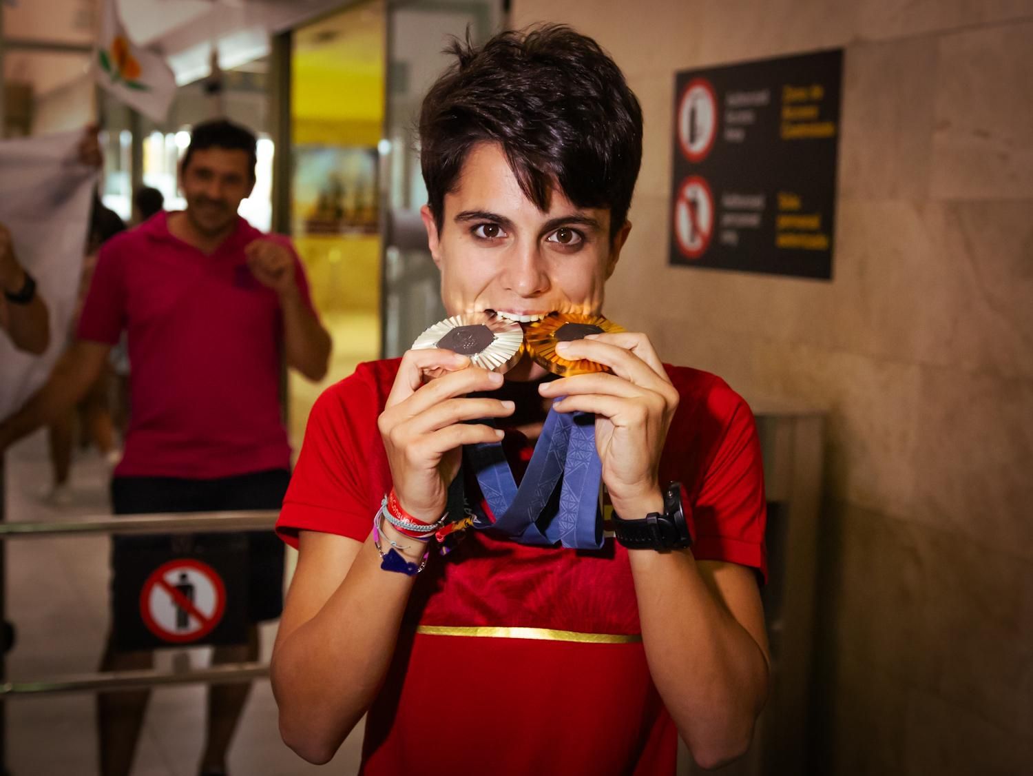 María Pérez muerde sus medallas.