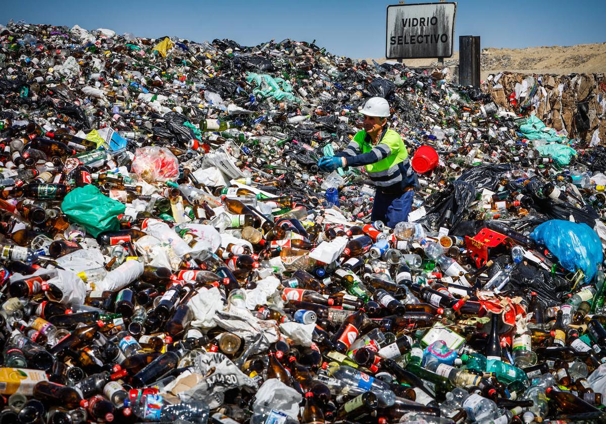 Un operario apila en el vertedero de Alhendín el vidrio reciclado en los contenedores verdes