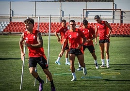 Los futbolistas del Granada esprintan entre picas durante el calentamiento del entrenamiento previo al partido contra el Albacete.