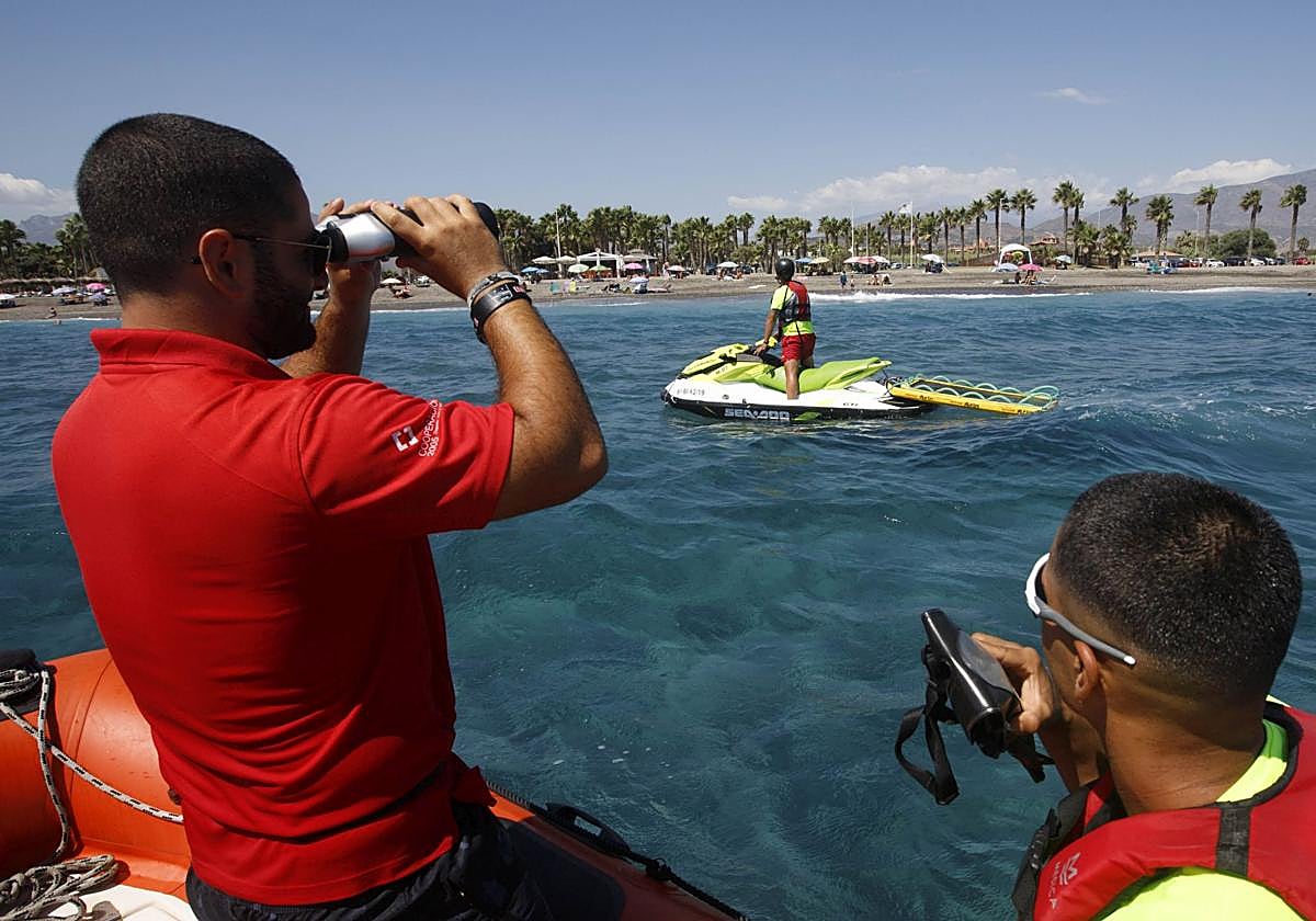 Los socorristas vigilan posibles problemas desde una lancha.