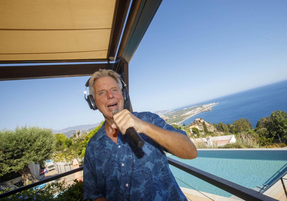 Dirk van Halewyck, en la terraza de su casa de Salobreña, ensayando micrófono en mano ycon el mar de fondo.