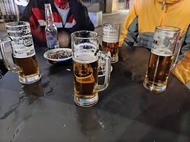 Jarras de cerveza en torno a la mesa de un bar.