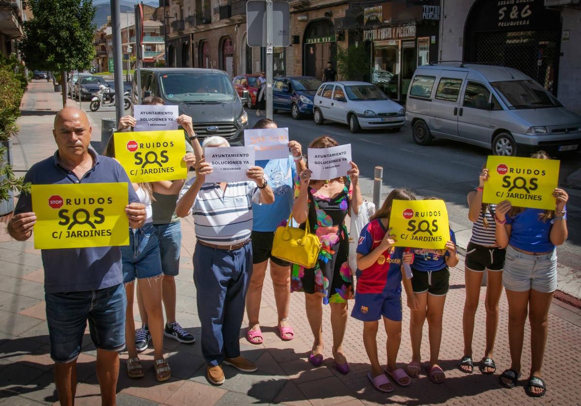 Vecinos de la calle Jardines de Armilla posan con pancartas reivindicativas.