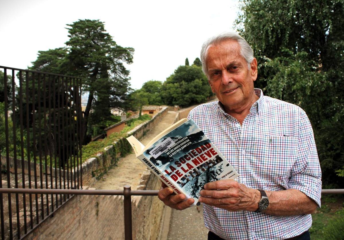 Eduardo Strauch en la Alhambra, con un ejemplar de 'La sociedad de la nieve', la novela que inspiró la película.