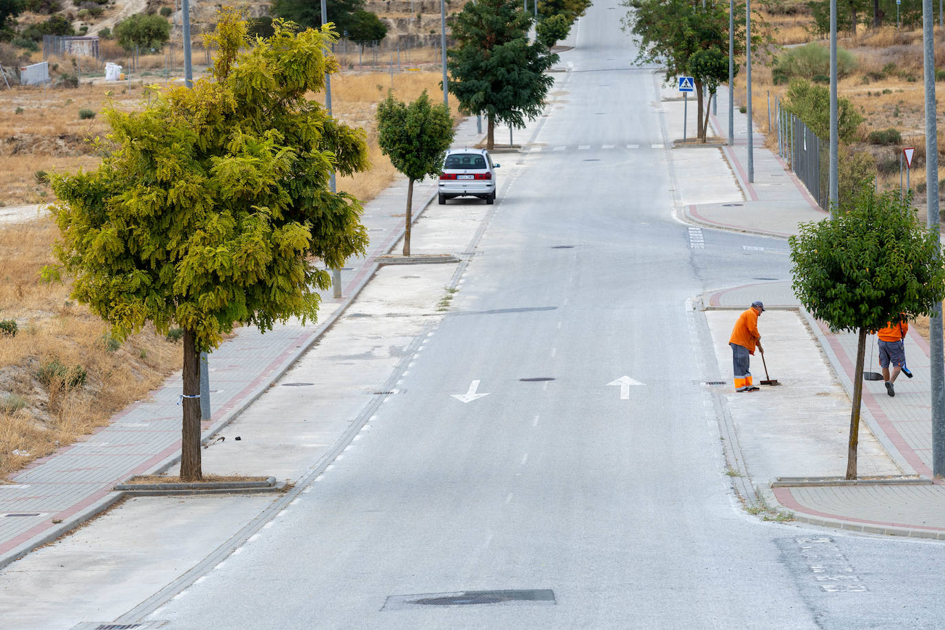 Trabajadores de mantenimiento de la entidad de conservación limpiando una de las calles de la urbanización.