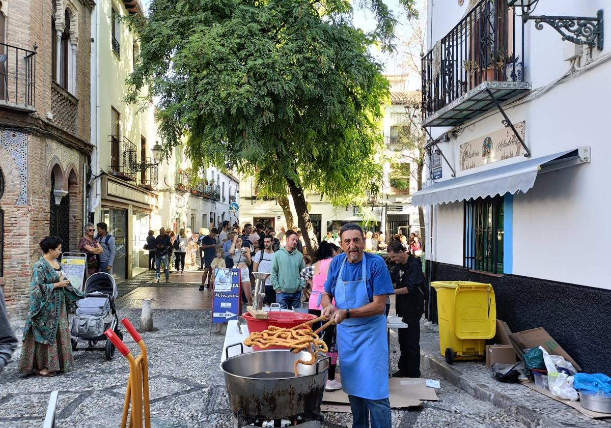 Imagen principal - Santi al mando de los churros en Plaza Larga, ambiente en la plaza y la larga cola para el chocolate.