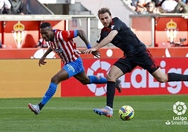 Ignasi Miquel, de negro, pugna por el balón ante un jugador del Sporting.